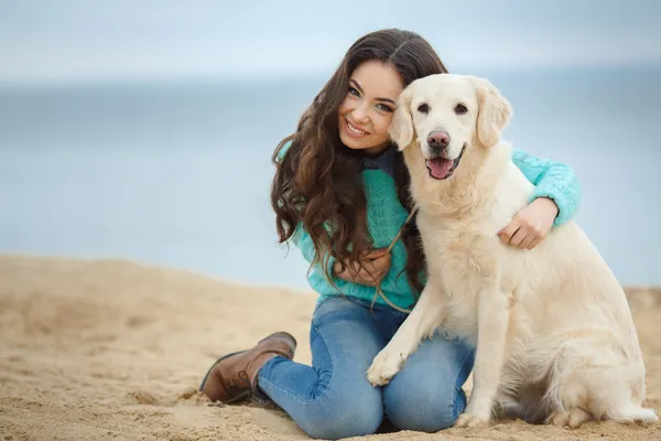 Портрет красивой молодой женщины, на берегу моря, играть с собакой — стоковое фото