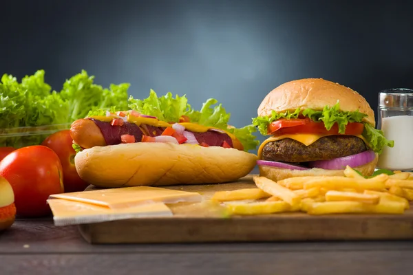 Сыр Бургер и хот-доги с большим количеством ингредиентов быстрого питания на фоне — стоковое фото