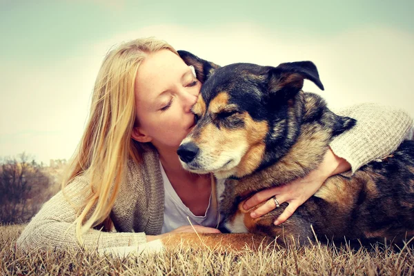 Женщина нежно обнимать и целовать собак — стоковое фото