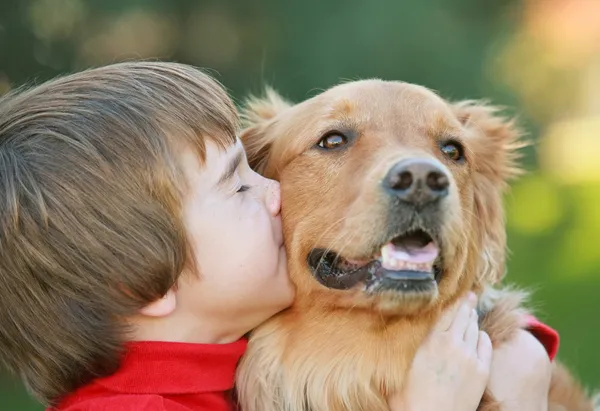 Мальчик целуя собака — стоковое фото