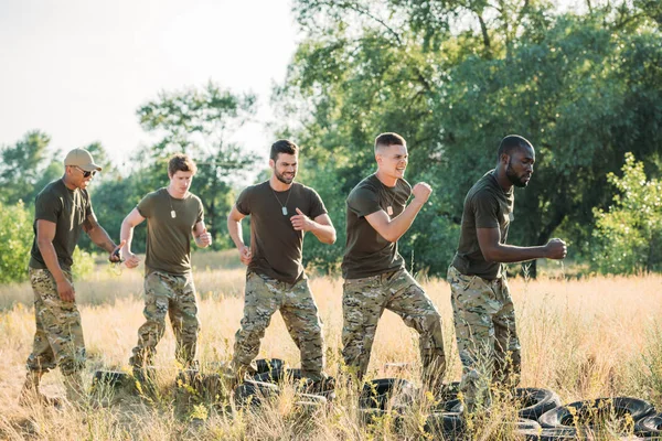 Side View Interracial Soldiers Practicing Tires Ground Range — стоковое фото