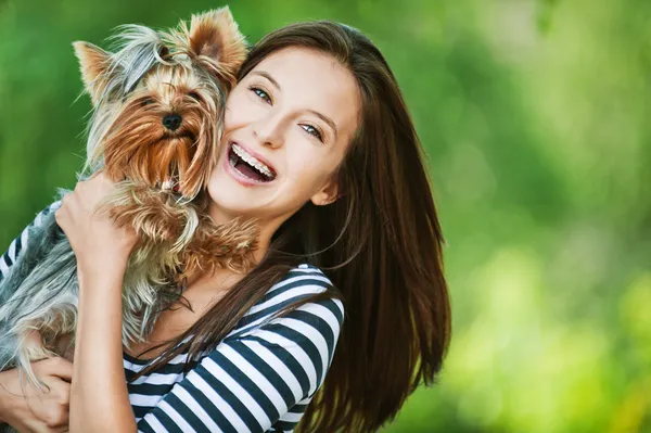 Женщина красивые молодые держит маленькую собаку — стоковое фото